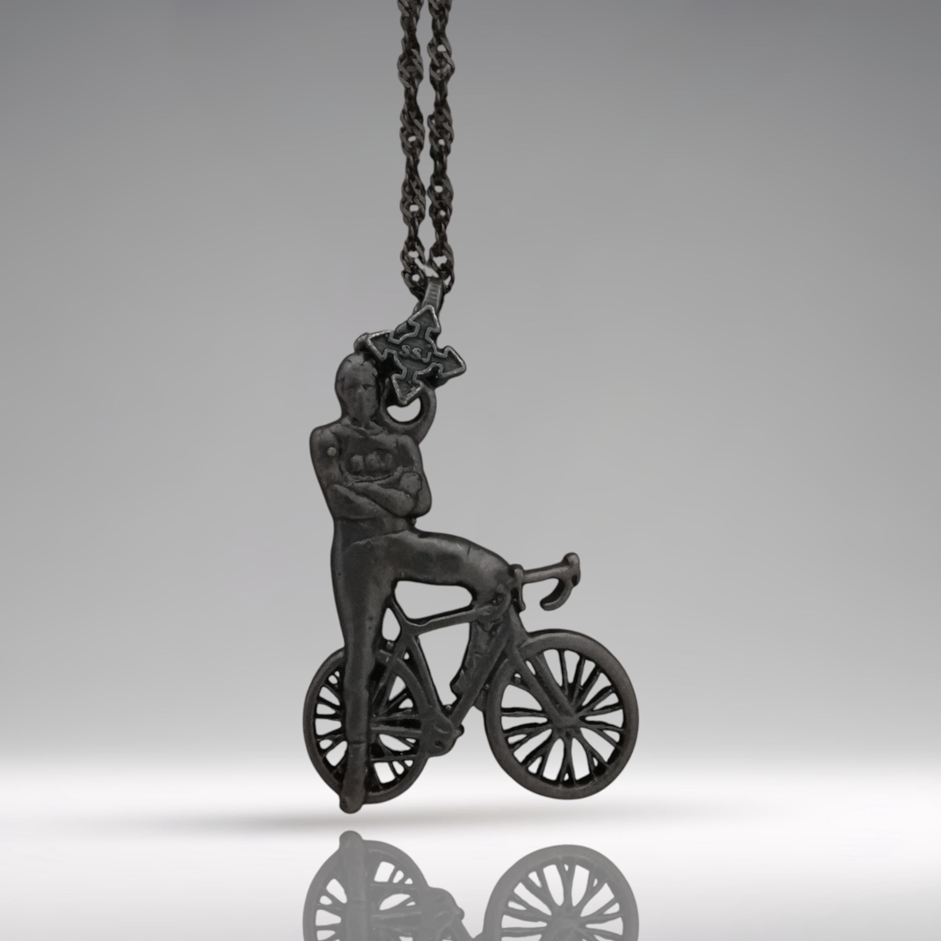 Black oxidized cyclist pendant handcrafted from solid 925 sterling silver — a rugged and masculine design for men who live with purpose, strength, and motion.

Featuring a confident rider standing beside his bike, arms crossed in pride, this piece embodies discipline, endurance, and an unshakable mindset. The matte oxidized black finish adds edge and intensity, making it a striking accessory for urban cyclists, fitness lovers, and bold personalities.