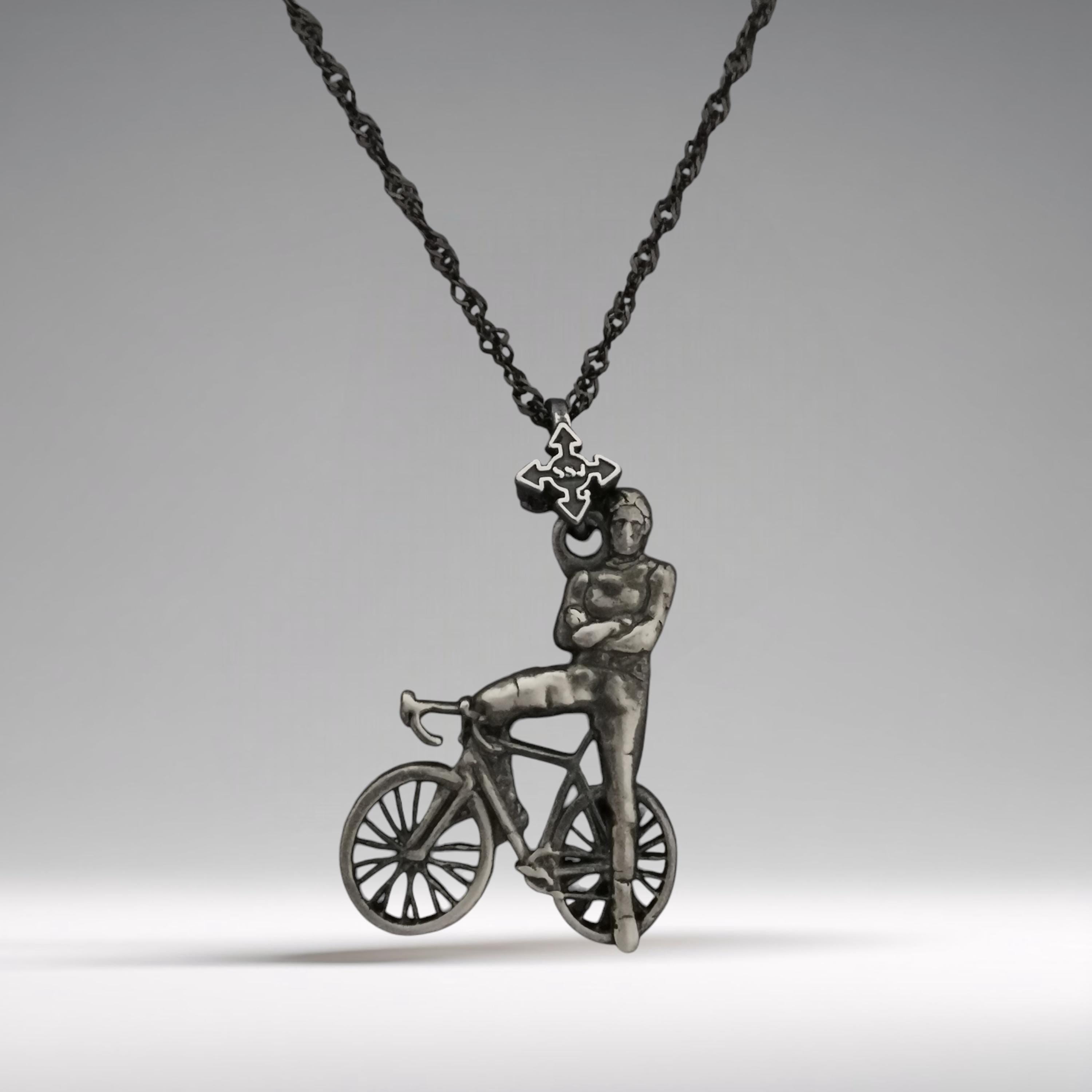 Vintage-style cyclist necklace handcrafted from solid 925 sterling silver — a striking pendant portraying the strength and calm confidence of a modern-day rider.

The design features a male cyclist leaning casually against his bicycle, arms crossed with pride — an emblem of dedication, control, and athletic identity. Finished in a soft vintage patina, this piece carries nostalgic energy and timeless masculinity.
