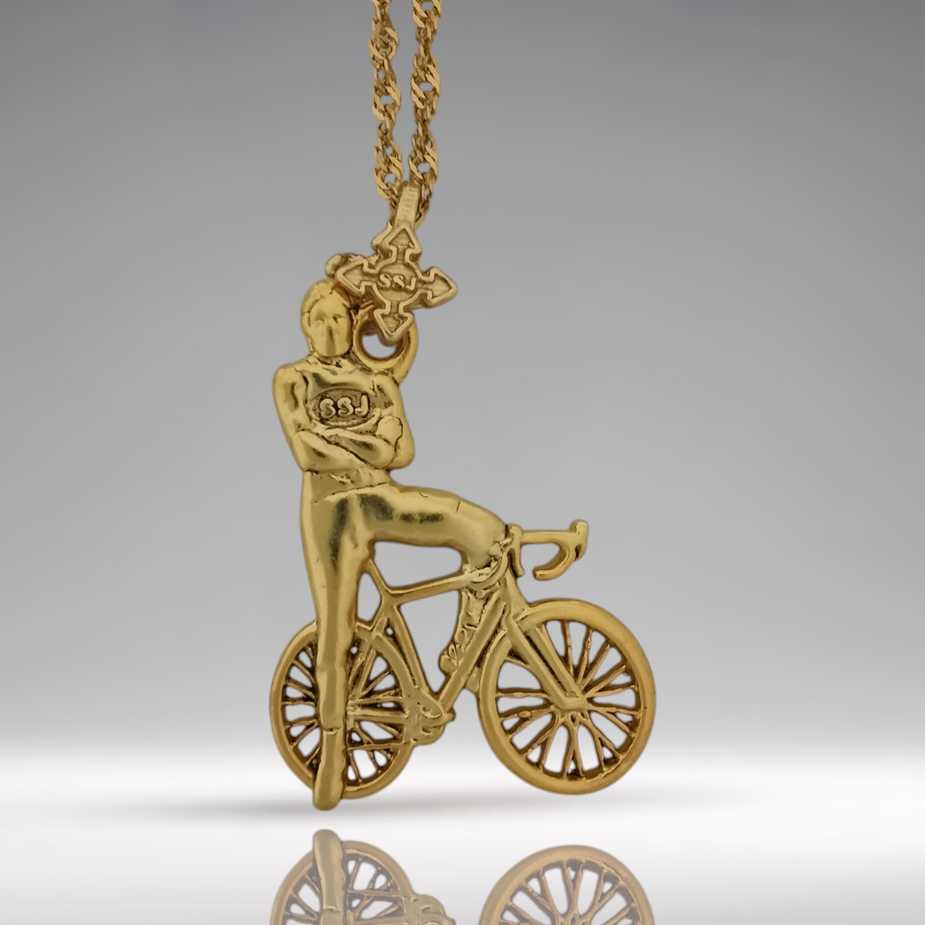 Gold-plated cyclist necklace handcrafted from solid 925 sterling silver — a bold pendant capturing the strength and confidence of a modern rider.

This detailed design features a male cyclist standing beside his racing bike in a proud, athletic pose — a symbol of passion, discipline, and freedom on two wheels. A wearable tribute to endurance and dedication, perfect for men who ride hard and live fast.