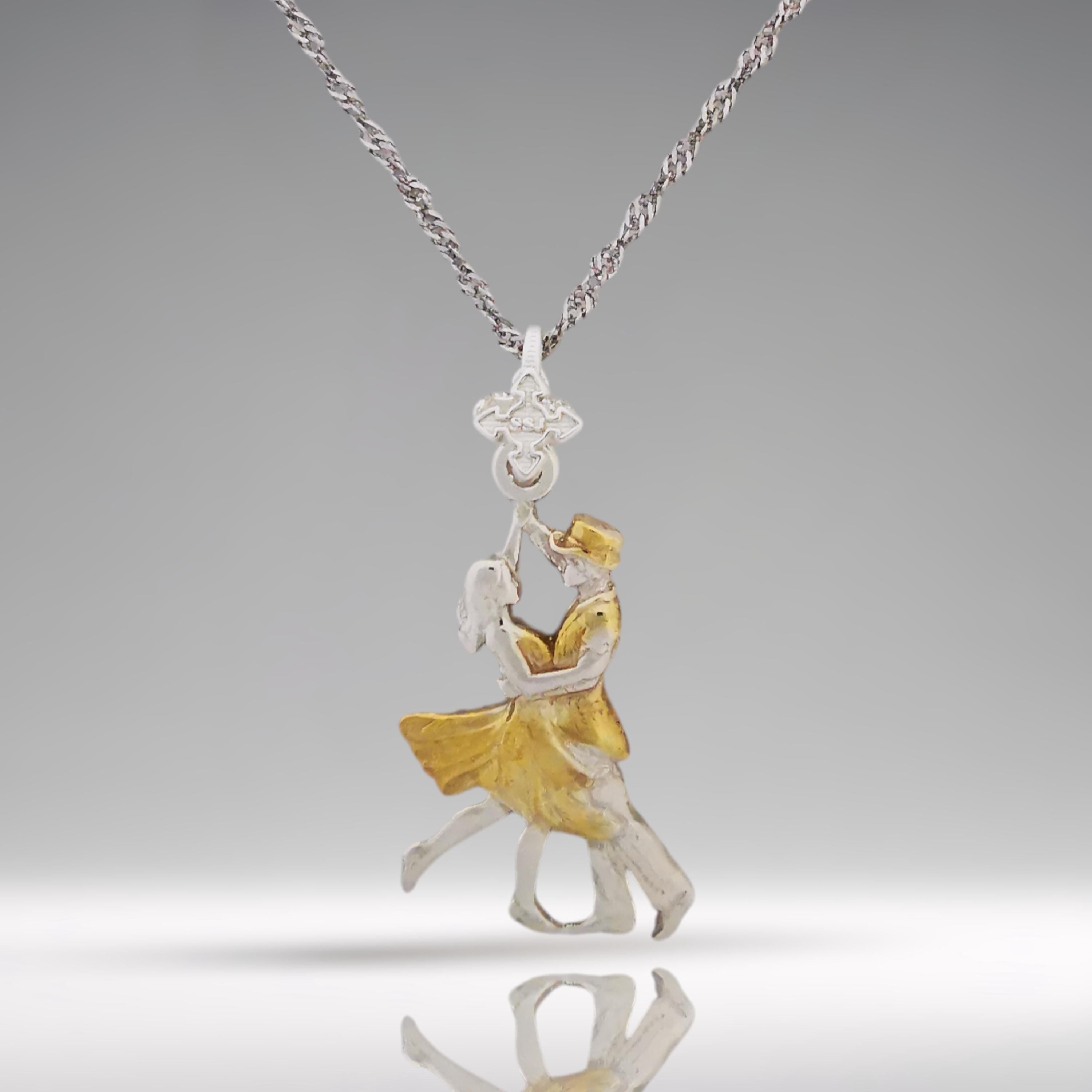 Looking for a romantic gift for her? This elegant two-tone tango pendant blends polished 925 sterling silver with graceful gold-plated accents — a tribute to the passion, precision, and connection found in Latin and ballroom dance.

The design features a dancing couple in fluid motion, symbolizing both the intensity of tango and the delicate harmony between strength and grace. The dual-metal finish adds timeless beauty and makes this piece