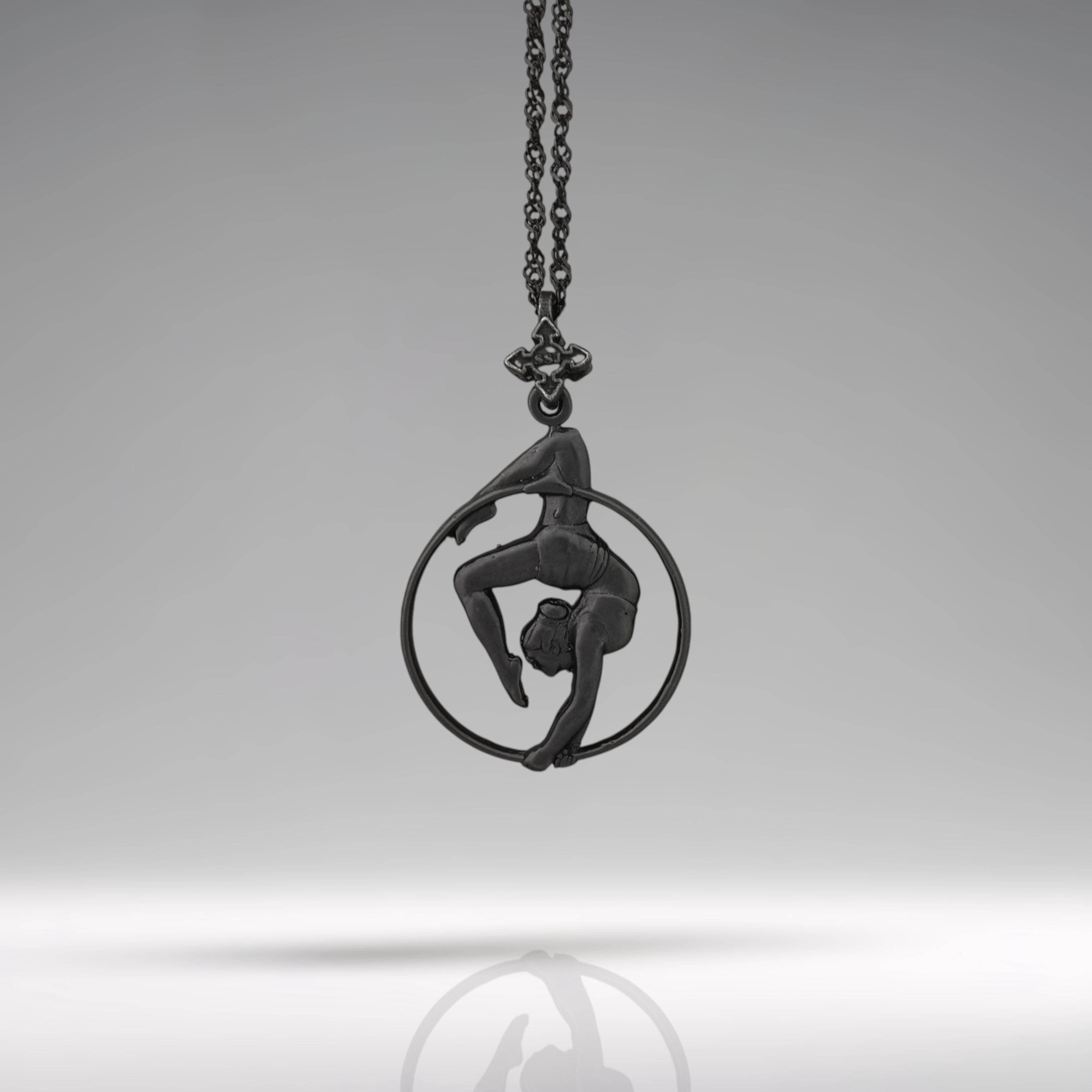 Black oxidized aerial hoop necklace crafted from solid 925 sterling silver — a dramatic and empowering pendant that celebrates aerial artistry, fluid motion, and fearless femininity.

This handcrafted piece features a woman in a graceful inverted pose within the hoop, capturing the strength, elegance, and poise of aerial dance. The deep matte black finish adds mystery and edge, transforming it into a bold symbol of control, beauty, and physical expression. Ideal for women who rise,